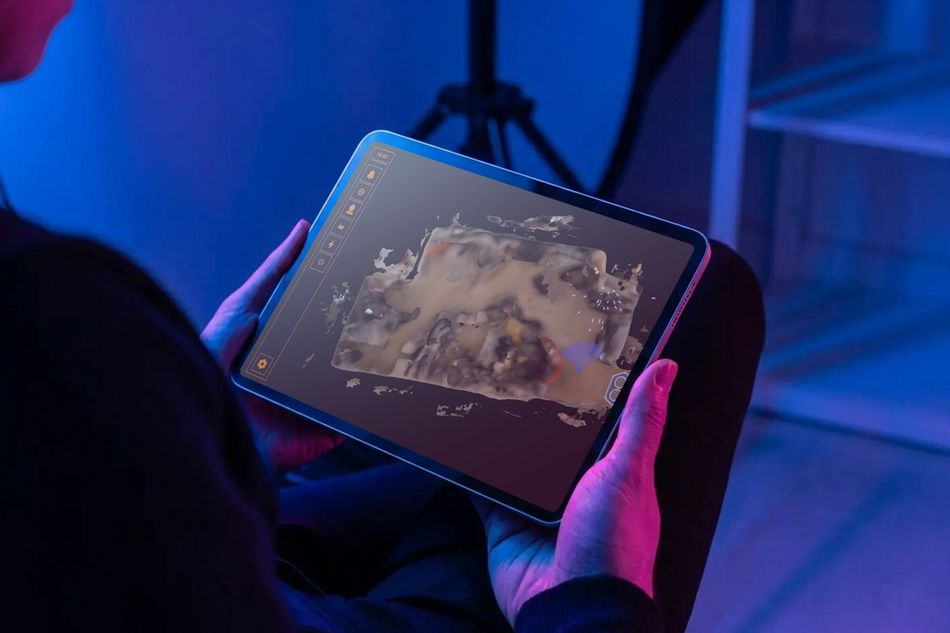玩家手持平板電腦，螢幕顯示遊戲場地的 3D 地圖
